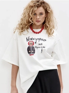 Detailed view of white cotton T-shirt featuring a stylized Matryoshka doll and text print