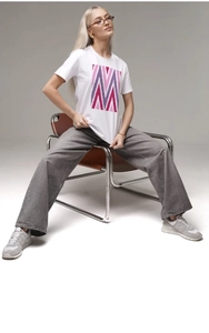 Détail d'un t-shirt blanc en coton avec imprimé géométrique rose et violet col rond