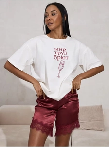 Detail von weißem Baumwoll-T-Shirt und burgunderroten Satin-Shorts mit Spitzenbesatz