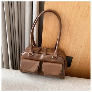 Detail of coffee brown faux leather shoulder bag with dual front square pockets