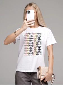 Detailed view of white cotton T-shirt featuring a colorful geometric diamond pattern print