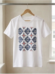 Detail of white cotton T-shirt featuring a blue geometric floral pattern on a hanger