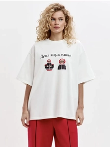 Gros plan d'un t-shirt blanc oversize en coton avec motifs poupée russe et texte en cyrillique