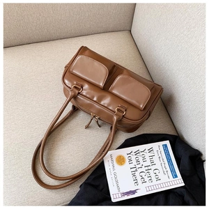 Detail of vintage dark brown PU leather shoulder bag with functional dual front flap pockets