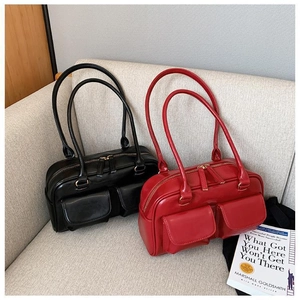 Detail of vintage Boston handbags in black and red with twin front pockets and top handles