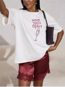 Detail von weißem Baumwoll-T-Shirt mit Grafik und burgunderfarbenen Satin-Shorts mit Spitze
