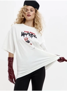 Dettaglio della t-shirt bianca oversize in cotone con stampa russa e guanti lunghi di pelle