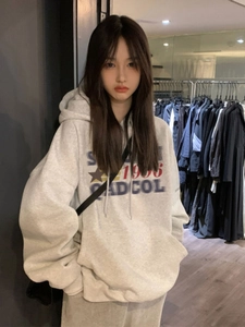Detailed close-up of grey oversized hoodie with 1996 vintage graphic and star print