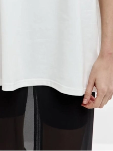Detail of double-needle stitching on white cotton T-shirt hem with layered black mesh style
