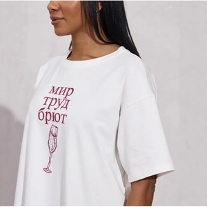 Minimalistisches weißes Baumwoll-T-Shirt mit kyrillischem Text und Champagnerglas-Print