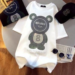 Détail d'un t-shirt blanc en coton avec un ours en strass brillant et texte de style urbain