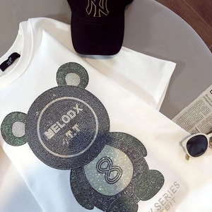 Détail d'un t-shirt en coton blanc avec un motif d'ours en strass brillants