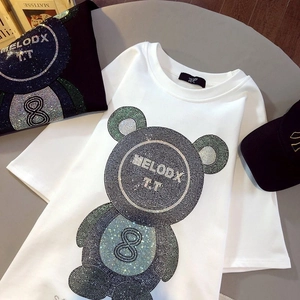 Détail du motif d'ours en strass brillants sur un t-shirt en coton de qualité supérieure