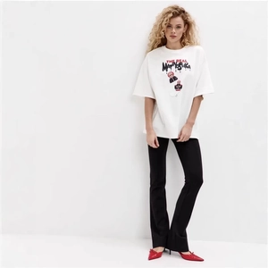 T-shirt oversize in cotone con stampa Matrioska e pantaloni neri a vita alta svasati