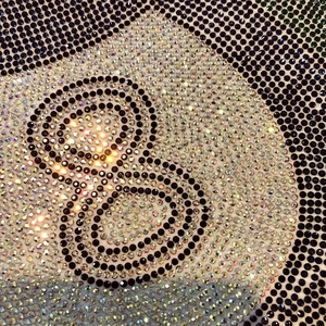 Détail macro du motif 8-ball en strass sur t-shirt en coton épais avec cristaux brillants