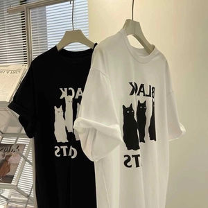 Détail de T-shirts en coton imprimés Black Cats en noir et blanc suspendus sur cintres