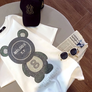 Détail d'un t-shirt blanc en coton avec un motif d'ours en strass brillants et scintillants