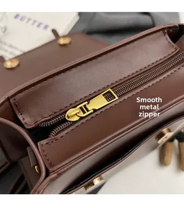 Detailed close-up of premium gold hardware zipper and smooth brown leather texture on backpack