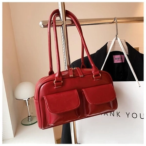 Macro shot of red PU leather handbag with two front pockets and smooth zipper detail