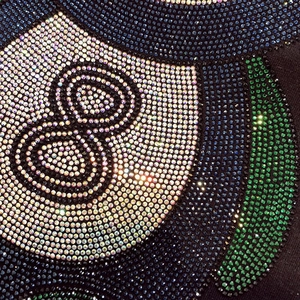 Vue macro détaillée de strass sur un t-shirt noir en coton avec le motif numéro 8