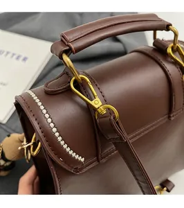 Detail shot of vintage dark brown backpack with golden D-ring hardware and white stitching