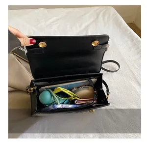 Capacità interna della borsa a tracolla in pelle nera con chiusura dorata e oggetti