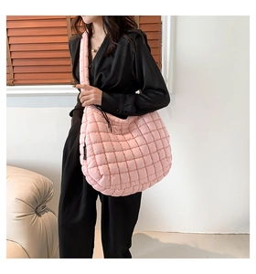 Close-up of pink quilted cotton shoulder bag with soft puffy texture and large grid pattern