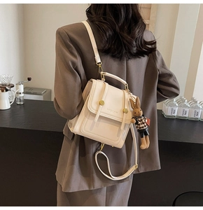 Detailed view of cream PU backpack featuring a gold clasp and a cute rabbit pendant