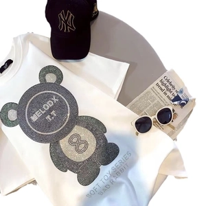 T-shirt en coton blanc avec motif ours en strass et accessoires de mode sur fond gris