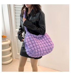 Dettaglio di una borsa tote viola trapuntata con cuciture a quadri e design imbottito soffice