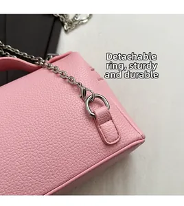 Detail of pink lychee textured leather bag with silver metal ring and detachable chain
