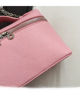Macro detail of pink lychee grain leather handbag with silver zipper and chain strap