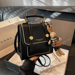 Vintage black leather backpack with metal beads and cute bunny charm in a gift box