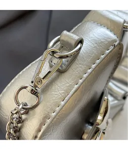 Detailed close-up of polished silver metal hooks and premium textured leather on the bag