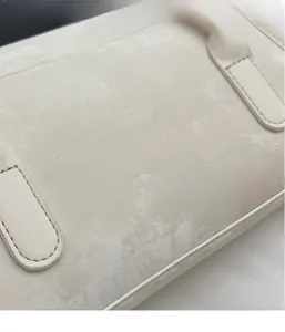 Close-up of the textured beige faux leather fabric and stitching on the shoulder bag