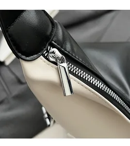 Détail de la fermeture éclair en métal argenté sur un sac bicolore noir et blanc