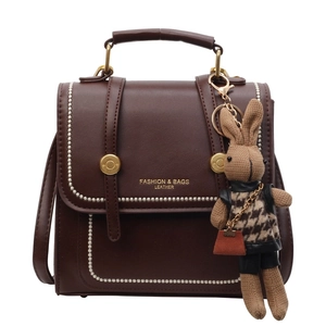 Retro dark brown leather backpack for women featuring a fashion gold logo and rabbit charm