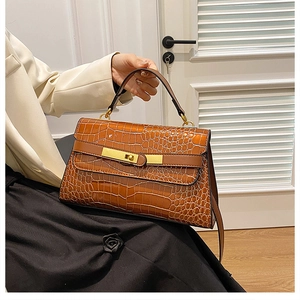 Dettaglio della pelle marrone coccodrillo e finiture dorate della borsa stile Kelly