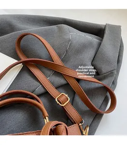 Close-up of adjustable strap with gold-tone buckle on brown pebbled leather bucket bag