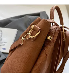Detail of brown lychee grain leather handbag with shiny gold metal hardware and stitching