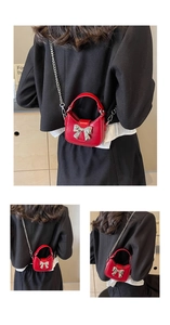 Detail of red patent leather mini bag with silver bow buckle and delicate chain strap