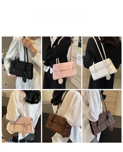Detail view of stylish underarm bags with thin double straps and circular pendants in multiple colors
