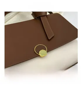 Detailed close-up of dark brown and beige patchwork handbag with gold metal lock