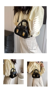 Detail of vintage black bowling bag with gold hardware and adjustable shoulder strap
