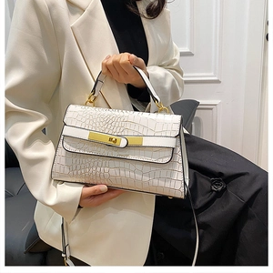 Dettaglio della borsa bianca in pelle goffrata coccodrillo con chiusura dorata