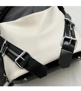 Détails de la boucle métallique argentée et texture de cuir sur le sac noir et blanc