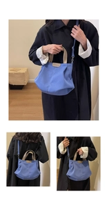 Detail of blue canvas tote bag showing the Budbao leather logo and sturdy brown handles