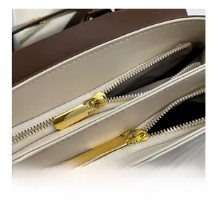 Detail of premium golden double zipper closure on cream and brown contrast handbag