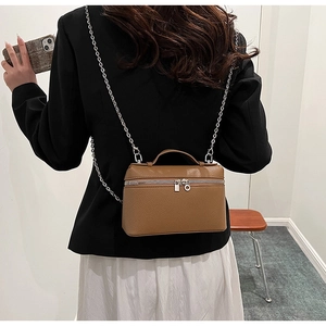 Detailed back view of a brown pebbled leather crossbody bag with silver chain strap