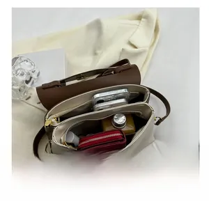 Detail view showing spacious interior compartments of the bicolor crossbody handbag